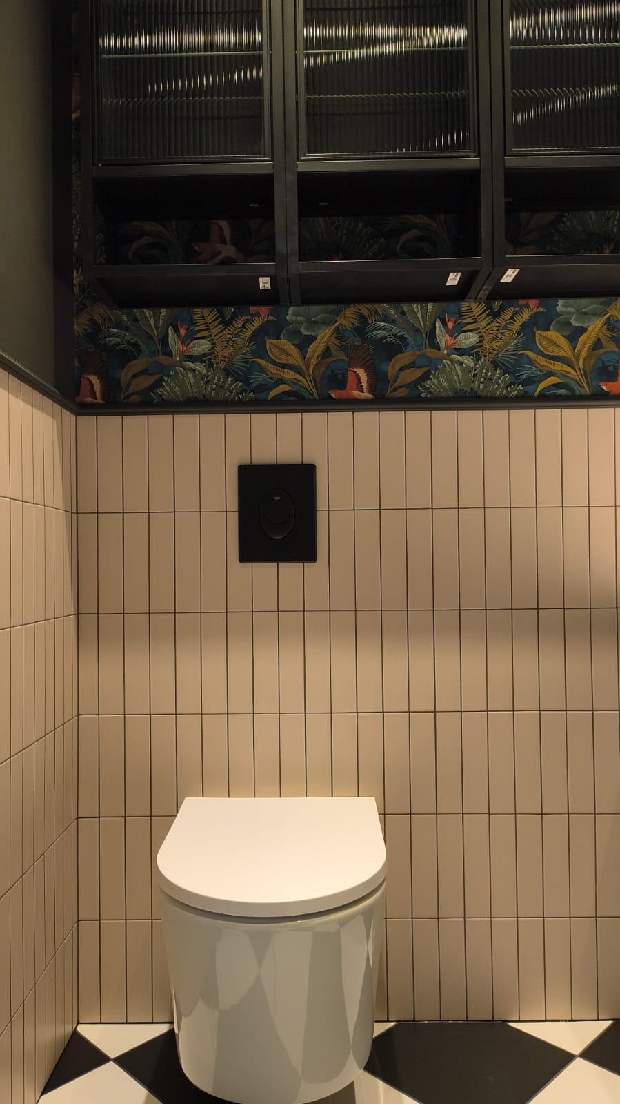 Miska WC podwieszana na tle jasnych pionowych płytek